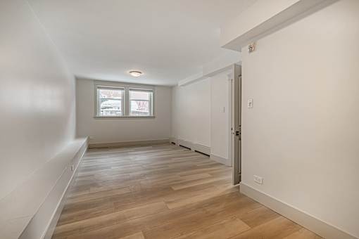 A room with wooden flooring and a window.