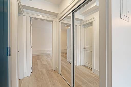 A hallway with a wooden floor and white walls.