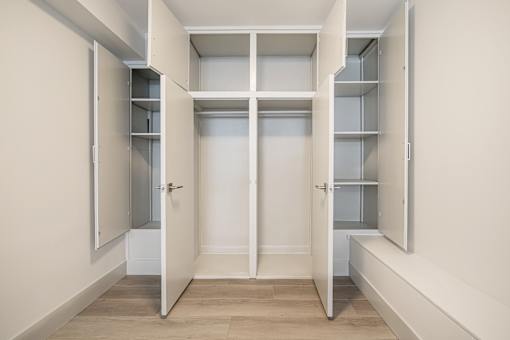 A white hallway with open doors leading to other rooms.