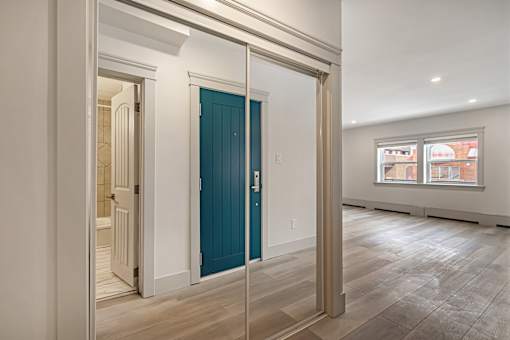 A room with a blue door and wooden flooring.