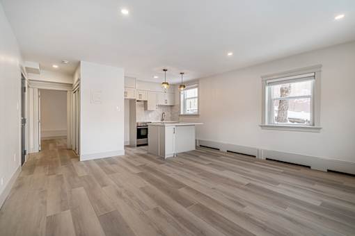 A kitchen with a white counter and a window.