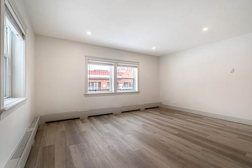 A room with a window and wooden flooring.
