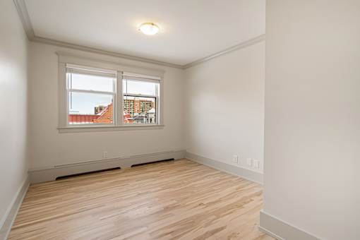 Empty room with wooden floor and white walls.