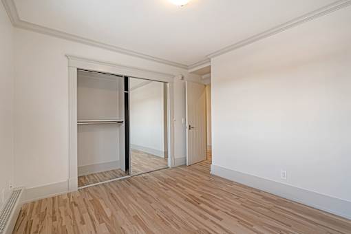 A room with a sliding door and wooden flooring.
