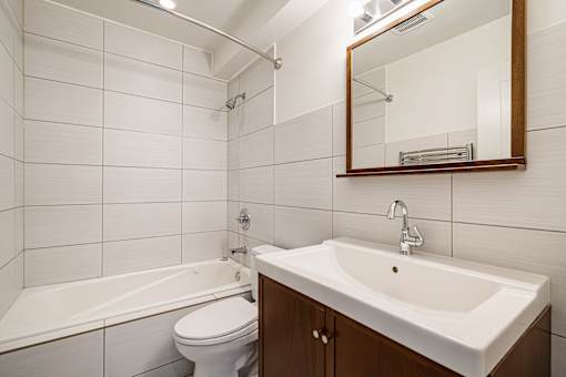 A white bathroom with a white toilet, white sink, and white bathtub.