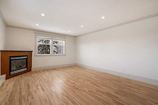 A room with a wood floor and a fireplace.