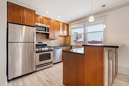 A modern kitchen with wooden cabinets and stainless steel appliances.