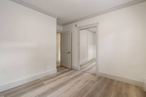 A room with a white wall and a wooden floor.