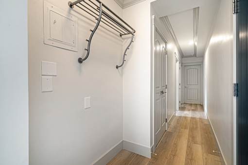 A long hallway with a towel rack on the wall.