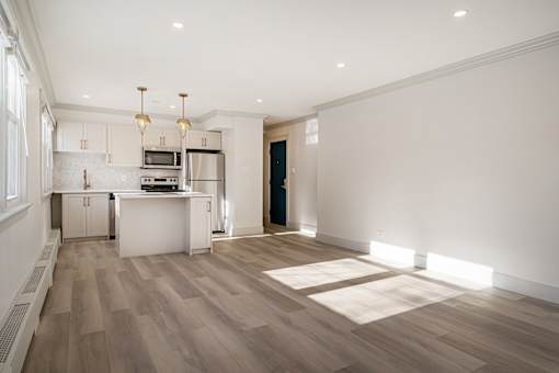 A kitchen with a refrigerator, oven, and microwave.
