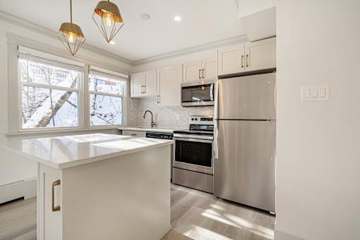 A kitchen with a stainless steel refrigerator and a white countertop.