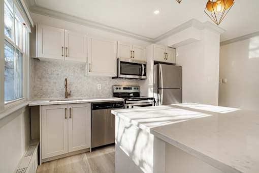A kitchen with white cabinets and appliances.
