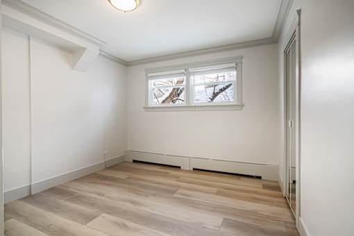 A room with a window and a radiator on the floor.