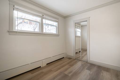 A room with a white wall and a wooden floor.