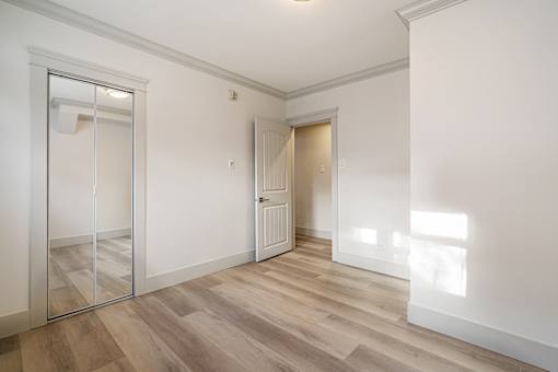A room with a wooden floor and a sliding glass door.