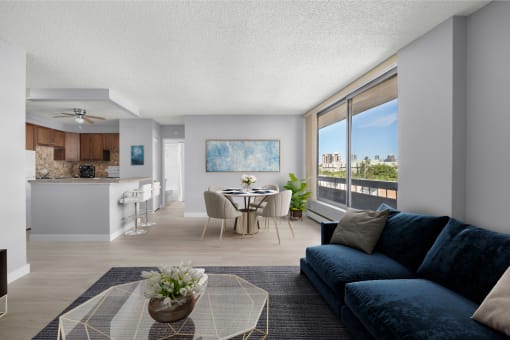 an open living room with a blue couch and a table with chairs and a kitchen