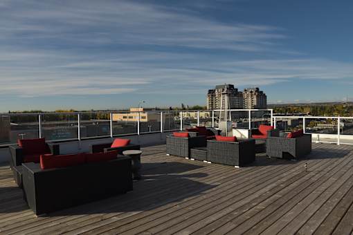 A wooden deck with red cushioned seating.