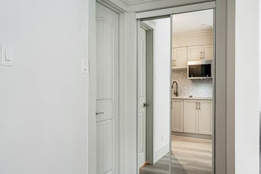 A white door is open to a kitchen.