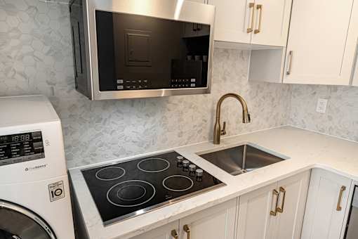 A modern kitchen with a stainless steel microwave above the stove.