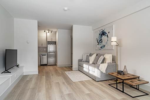A modern living room with a grey sofa and a wooden coffee table.