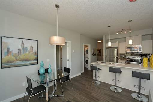 A modern kitchen with a bar area and a dining table.