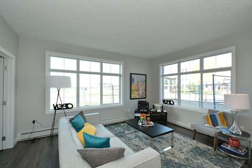 A living room with a white couch, a black coffee table, and a large window.