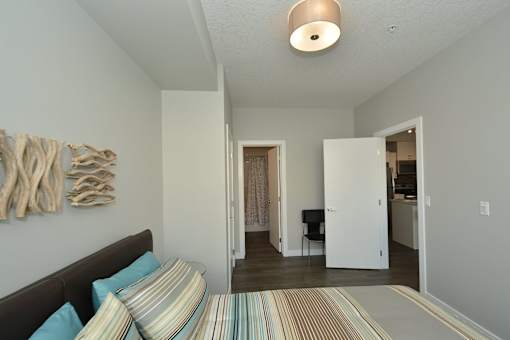 A bedroom with a bed and a chair in it.