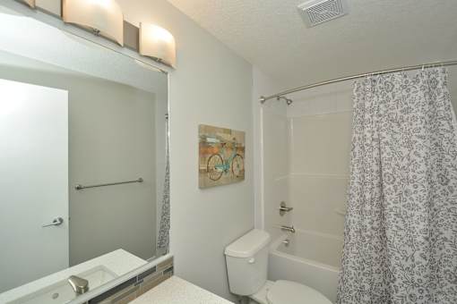 A bathroom with a toilet, sink, and shower.