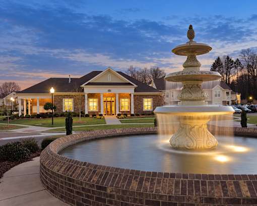 A beautiful house with a fountain in front of it.