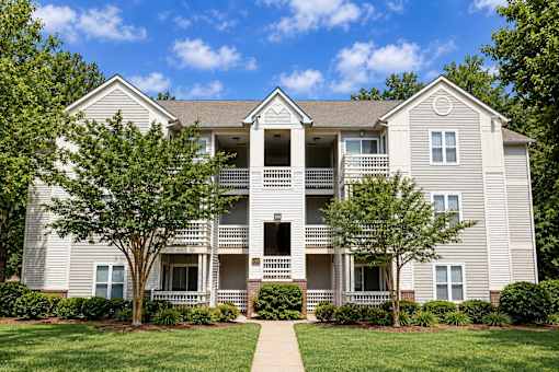 A two-story apartment building with a balcony on the second floor.