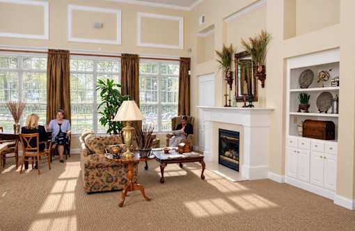 A living room with a fireplace and a large window.