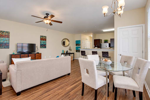 A living room with a couch, chairs, and a television.