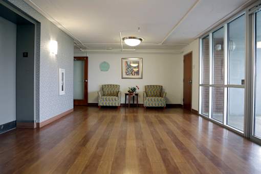 A hallway with wood floors and a painting on the wall.