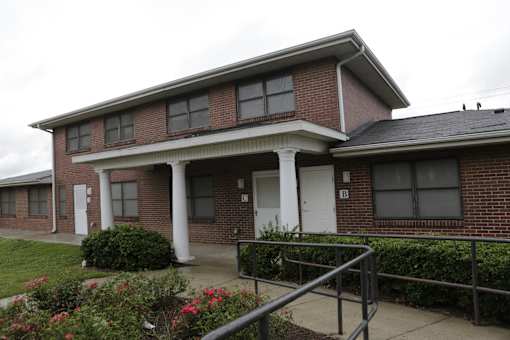 A red brick house with a white door and windows.