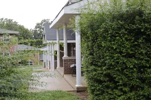A porch with a white railing and pillars.
