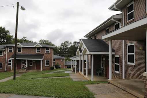A row of houses with a grassy area in between.