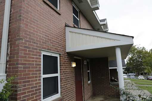 A red brick house with a white door and window.