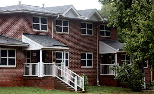 A red brick house with a white porch.