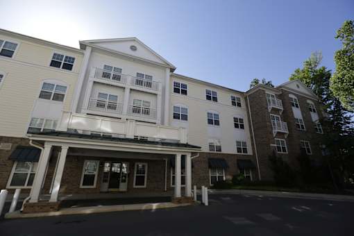 A large white building with a balcony on the second floor.
