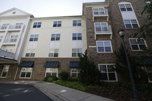A street view of a residential building with apartment balconies.