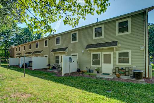A row of houses with green lawns in front.