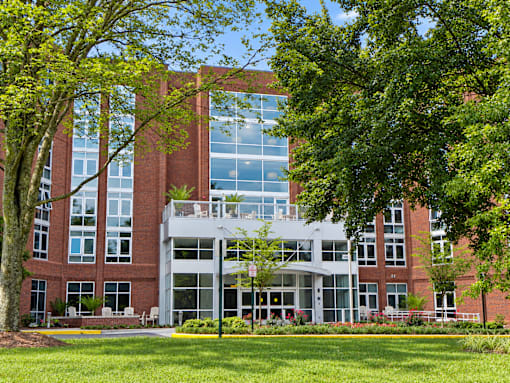 A large red brick building with a green lawn in front.