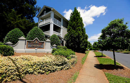A building with a sign that says Gardens in front of it.