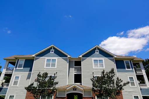 A large two-story apartment building with a balcony on the second floor.