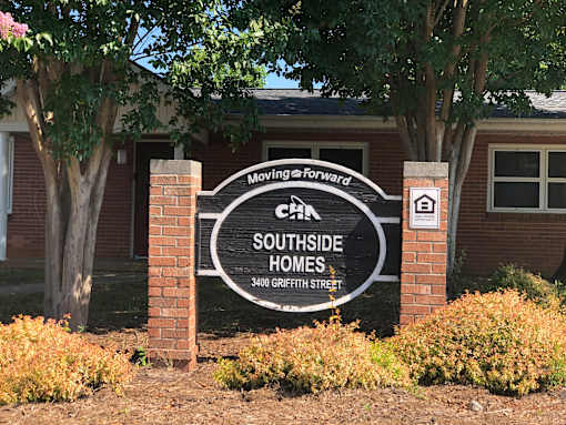 A sign for Southside Homes stands in front of a building.