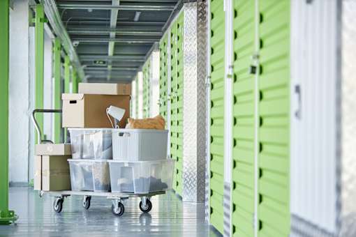 A storage room with a green wall and a cart with boxes on it.