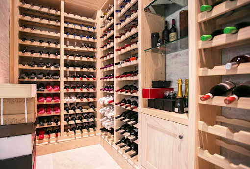 A wine-storage room with a variety of wine bottles and other stored items.