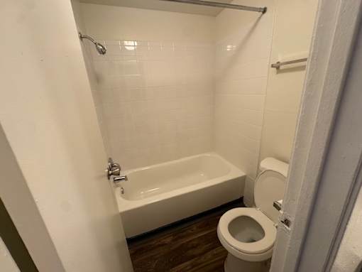 A bathroom with a white tub and toilet.