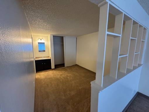 A bedroom with a carpeted floor and closet.