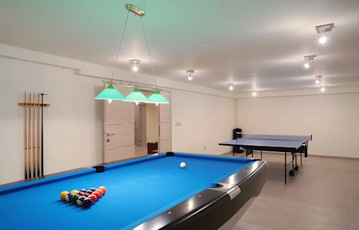 A pool table with a blue cloth and a white ball in the middle.